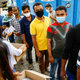 Bangladeshi migrant workers in Singapore queue to collect free masks.